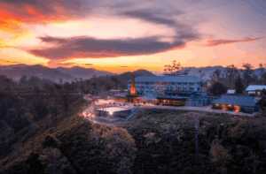 Aerial view of Newburgh Ella tea factory resort surrounded by tea terraces and hills.